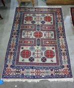 Cream ground Eastern rug with red and cream ground central medallions, the castellating margin in