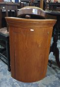 Contemporary polished wood small bowfronted corner cupboard with stepped cornice and a circular