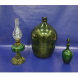 Green glass carboy, a green glass decanter and an oil lamp with metal base and green glass reservoir