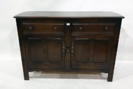 Dark elm Ercol dresser base with two short drawers and two cupboard doors and a table and six chairs