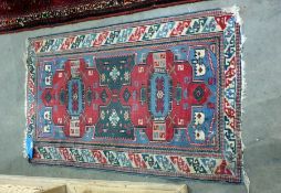 Red ground Eastern rug in reds, greens, blues and creams, 114cm x 71cm