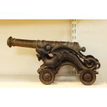 Decorative late 19th century brass cannon with turned barrel, on cast iron carriage modelled as a