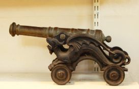 Decorative late 19th century brass cannon with turned barrel, on cast iron carriage modelled as a