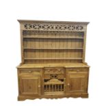 20th century pine dresser with moulded pediment above three shelves, on a base of assorted