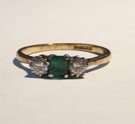 Gold three-stone diamond and emerald ring, the central square cut emerald flanked by two brilliant
