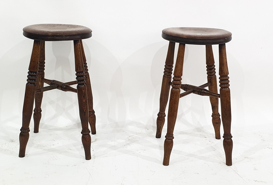 Pair of elm circular stools on four turned supports united by cross stretchers, 55cm high