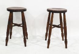 Pair of elm circular stools on four turned supports united by cross stretchers, 55cm high