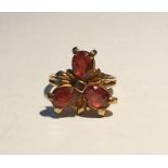 9ct gold and garnet ring set with three teardrop shaped mixed cut garnets, in a flowerhead design,