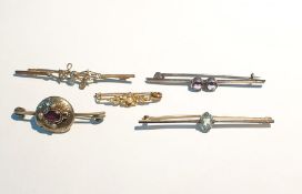 Gold-coloured bar brooch set with central oval mixed cut blue zircon, unmarked, a silver bar