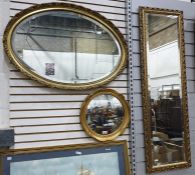Three various gilt framed mirrors including a tall bevelled edged dressing mirror, a large oval