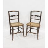 Pair of cane seated side chairs with turned and carved top rails, carved and pierced and turned rail