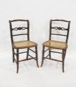 Pair of cane seated side chairs with turned and carved top rails, carved and pierced and turned rail