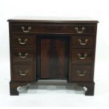 George III style mahogany kneehole desk with single frieze drawer above panelled cupboard flanked by