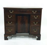 George III style mahogany kneehole desk with single frieze drawer above panelled cupboard flanked by