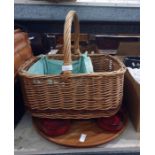 Wicker picnic basket with some ceramic plates and napkins, other baskets and a lazy susan with red