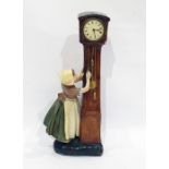 Continental mantel clock in the form of Dutch girl adjusting a longcase clock