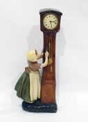 Continental mantel clock in the form of Dutch girl adjusting a longcase clock