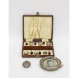 Silver sovereign case of circular hammered form, a small silver photograph frame of circular form