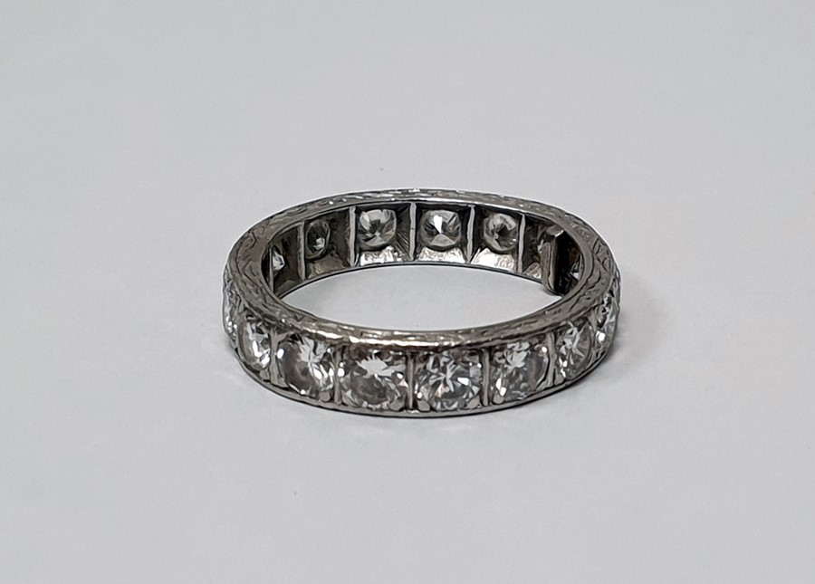 Platinum and diamond eternity ring, with engraved sides, 17 diamonds, ring size P approx