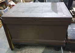 Large stained toolbox raised upon wheels and conte