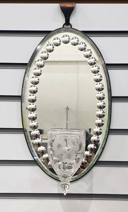 19th century candle mirror-back wall sconce, the oval bevel edged mirror featuring roundel design to
