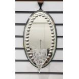 19th century candle mirror-back wall sconce, the oval bevel edged mirror featuring roundel design to