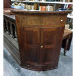 19th century mahogany bowfront wall hanging corner cupboard, the two doors enclosing shelves, with