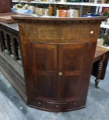 19th century mahogany bowfront wall hanging corner cupboard, the two doors enclosing shelves, with