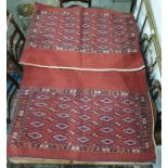 Pair of red ground camel saddle bags decorated with five hooked medallions to the red ground