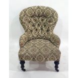 Low Victorian nursing chair with a cream ground patterned upholstery, on mahogany turned legs to