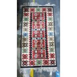 Cream ground rug with long red ground lozenge, in creams, greens, reds, blacks, taupes and blues,