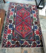 Persian style wool rug, the red ground with two lozenge medallions and geometric border, 192cm x