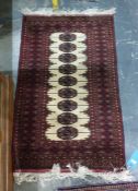 Persian style wool rug with elephant’s foot gul on cream ground, black and red borders, 140cm x 81cm