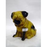 Continental porcelain model of a pug seated on its haunches, 20th century, its fur glazed in ochre