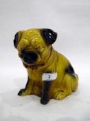 Continental porcelain model of a pug seated on its haunches, 20th century, its fur glazed in ochre