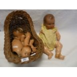 Various composite doll parts including one complete doll but all AF within a wicker dolls rocking