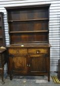 A 20th century oak dresser with two shelves above two drawers and two cupboard doors
