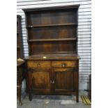 A 20th century oak dresser with two shelves above two drawers and two cupboard doors