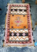 Orange ground carpet with central medallion, in oranges, creams, pinks and browns, 145cm x 82cm