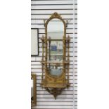 Giltwood mirrored wall-hanging bracket with three-tiers, the arched top with floral and foliate