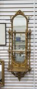 Giltwood mirrored wall-hanging bracket with three-tiers, the arched top with floral and foliate