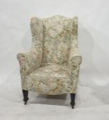 19th century wing back armchair in cream ground foliate patterned upholstery, raised on square