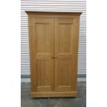 A 20th century pine wardrobe compactum, the left hand door enclosing hanging space, the right hand