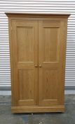 A 20th century pine wardrobe compactum, the left hand door enclosing hanging space, the right hand