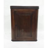 A 19th century mahogany wall-hanging corner cabinet with moulded cornice above single panel door