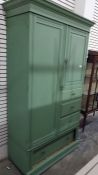 A green painted compactum, the left hand door enclosing shelves, the shorter right hand drawer above