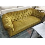 A Victorian button-back Chesterfield sofa in olive green upholstery, on turned supports to castors