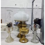 Two brass paraffin lamps, and two other paraffin lamps, one with moulded glass base showing flying