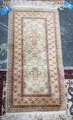 Modern silk Eastern wool rug in geometric decoration in shades of red on cream ground