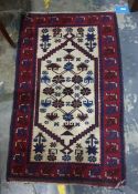 Cream ground rug with foliate motifs, on a red ground border, 131cm x 79cm